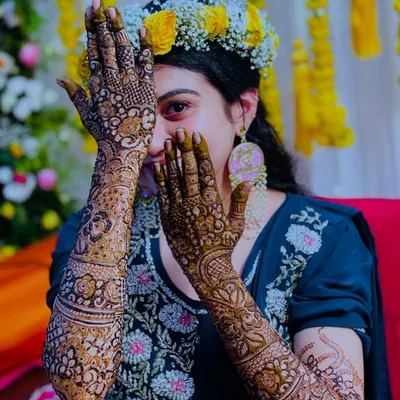 A beautiful, happy bride peeking through her intricately designed hands. Her joy is what makes my work so rewarding.