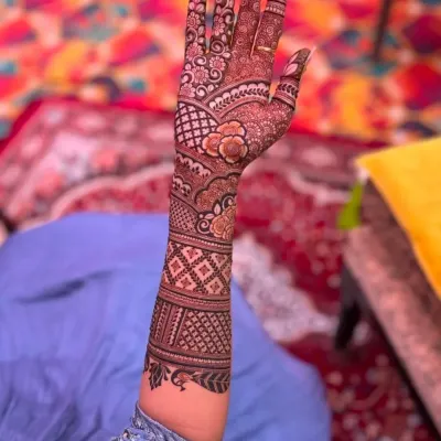 A beautiful example of engagement mehndi, with a focus on floral patterns and a delicate net design on the back of the hand.