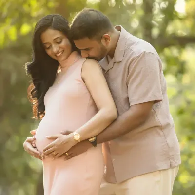 A sweet kiss and a loving embrace, surrounded by the beauty of nature. The golden hour light makes this outdoor maternity portrait feel extra warm and romantic.