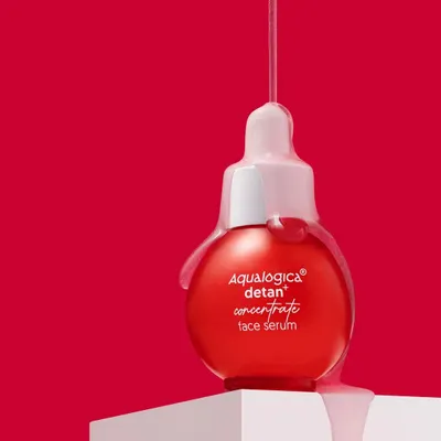 This shot is all about capturing that perfect, glossy drip. We used a bold red background and precise lighting to highlight the serum's texture as it cascades over the bottle, creating a visually arresting image that screams luxury.