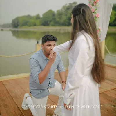 "Forever starts and ends with you." A classic proposal moment, with the groom down on one knee, kissing her hand on a beautifully decorated pier at Honeybook Studios.