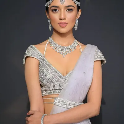 A stunning bridal look for a modern bride. The sleek, low bubble braid is accessorized with a diamond matha patti for a look that is simple, elegant, and incredibly chic.