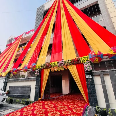 A grand entrance decoration for a wedding house. I used red and yellow drapes to create a massive, welcoming tent structure that makes a statement.