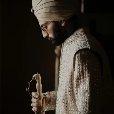 Elegance personified. This portrait of the groom captures a moment of quiet reflection, redefining royal charm and showcasing the intricate details of his wedding attire.