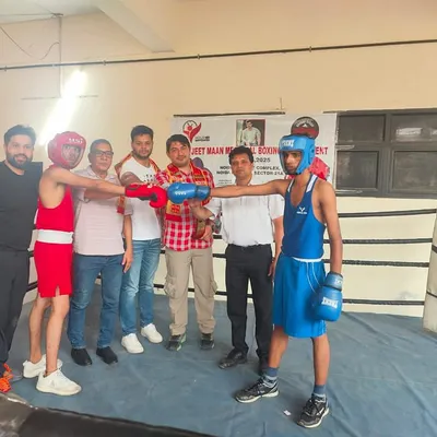 Two young fighters ready for a bout at the Jeet Maan Memorial Boxing Tournament, with officials present. This is a formal competitive environment where they apply their training.
