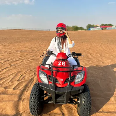 Kicking off my desert adventure in Abu Dhabi with some quad biking. I'm wearing a comfortable all-white outfit with a keffiyeh scarf for a practical and stylish desert look.