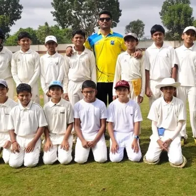 Our young team with their coach, ready for a match on a well-maintained grass field.