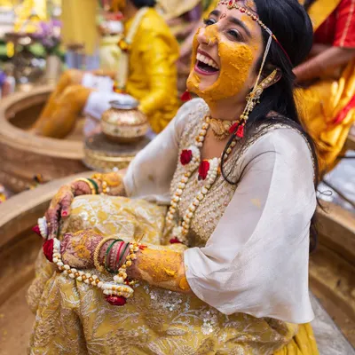 A moment of pure, unadulterated laughter from the bride during her Haldi ceremony. These are the candid shots that truly capture the spirit of the day.
