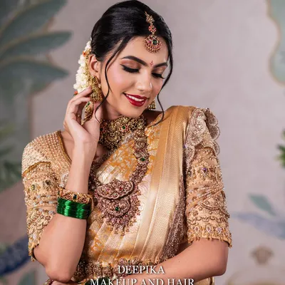 A close-up of a radiant South Indian bride. Notice the soft, shimmering eye makeup and the perfectly blended base that enhances her natural beauty, paired with a classic red lip.