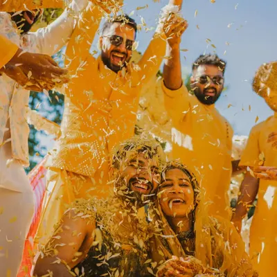 The grand finale of a fun-filled Haldi, with the couple and their friends celebrating amidst a shower of flower petals. This is pure, unfiltered joy.