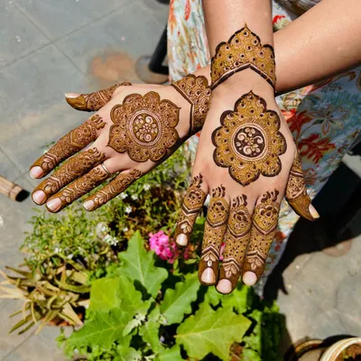 A beautiful and sunny shot of a modern mandala design. The patterns on each hand are different but complementary.