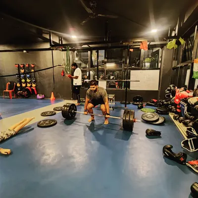 The deadlift is a fundamental test of strength. Here, a client is in position for a heavy lift, surrounded by the tools of our trade. We build strength from the ground up.