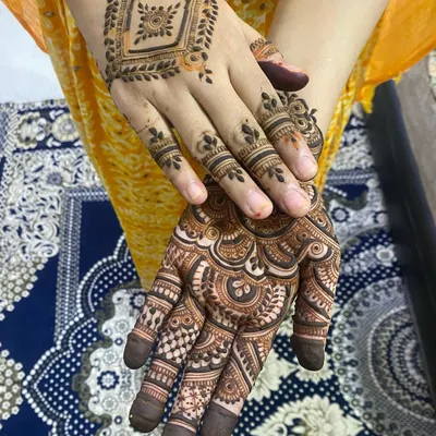 A beautiful combination of two different styles on each hand, one with a geometric pattern and the other with a more traditional, full-palm design.