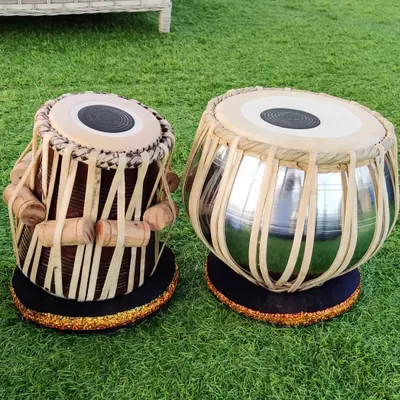 This professional tabla set, featuring a chrome-finished bayan, is ready for delivery. We ensure every pair, like this one set on our lawn, meets high standards for performance and durability.