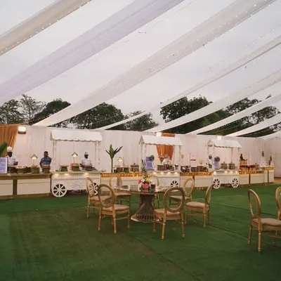 Serving style, flavor, and flair. A wide view of our outdoor catering setup, featuring elegant white food carts and guest seating on a lush green lawn.