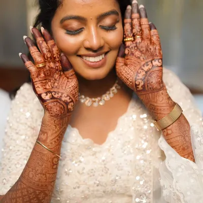 A smiling bride showing off her beautiful, dark henna stain. My goal is always to create bridal henna that brings joy and makes you feel amazing on your wedding day.