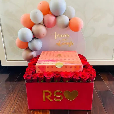 A truly romantic gesture for your forever and always. This custom red box is filled with dozens of fresh roses and topped with a personalized balloon arch and a box of luxury sweets.