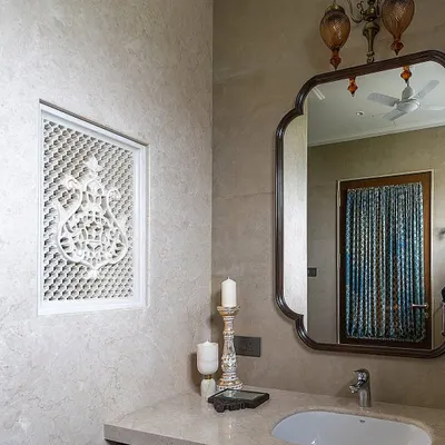 In this Hyderabad home, we used a handcrafted lattice panel, or *jaali*, to divide the shower and dry areas in the bathroom. This traditional element, rooted in Indian and Middle Eastern architecture, adds a beautiful, functional detail that balances minimalism with a love for craft.