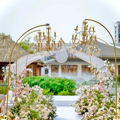 An absolutely enchanting wedding entrance. We designed this walkway with golden arches holding magnificent chandeliers, surrounded by a garden of pastel pink and white flowers.