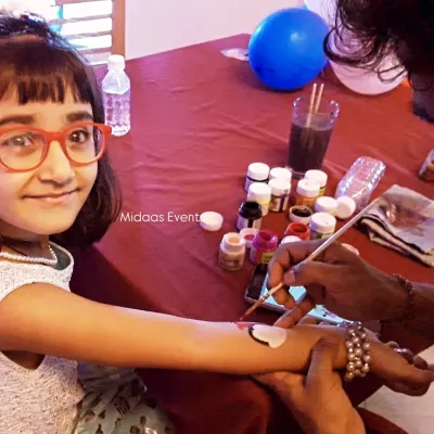 This young guest is all smiles as she gets her arm painted at the temporary tattoo stall. I hire professional and friendly artists who are great with children, ensuring a safe and fun experience for everyone.