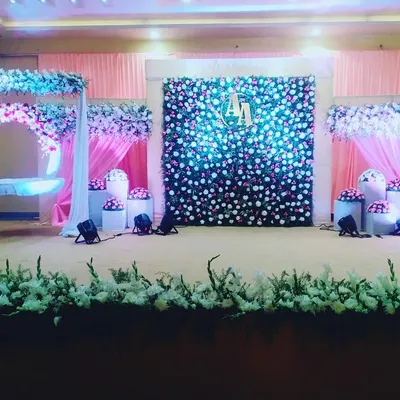 This is our complete stage setup for a grand naming ceremony. It includes the floral swing, a stunning flower wall with custom initials, and soft pink draping for a cohesive and elegant look.
