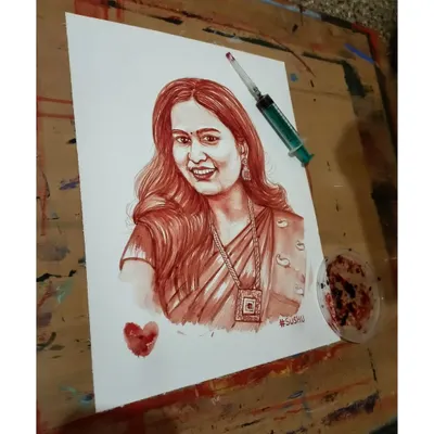 This photo shows a finished blood portrait on my easel, next to the syringe used for collection. I follow a professional and hygienic process for every piece.
