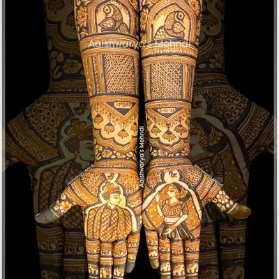 A complete bridal story with portraits of the bride and groom on each palm. The arms are decorated with traditional elements like parrots in jharokhas and personalized name designs, telling a full wedding story.