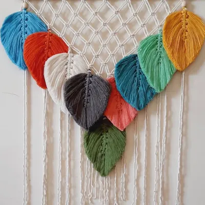 This wall hanging is a beautiful showcase of my macrame leaves. It features a cascade of leaves in many different colors, creating a vibrant and natural look.
