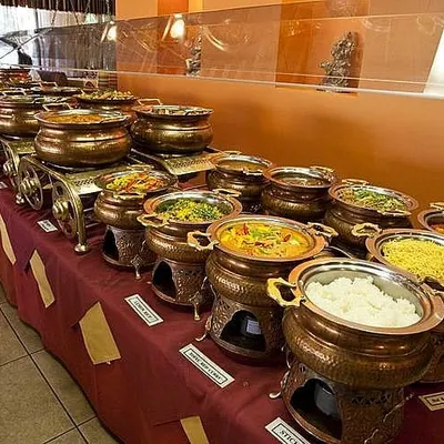 A look at our traditional buffet setup, featuring authentic copper and brass serving dishes. This arrangement is perfect for weddings and cultural events, showcasing a wide array of dishes while keeping them warm for your guests.