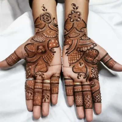 A classic Arabic mehandi design, featuring bold floral and paisley patterns that flow diagonally across the hands.