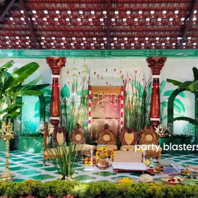 This is my signature South Indian muhurtham decor. The stage is set under a traditional tiled roof, featuring hand-carved pillars, large banana plants, and a custom-painted backdrop that brings the essence of Kerala to your wedding.