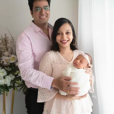 A beautiful first family portrait. I use soft, natural light from the window to create a bright and airy feel, highlighting the peaceful joy of new parenthood.