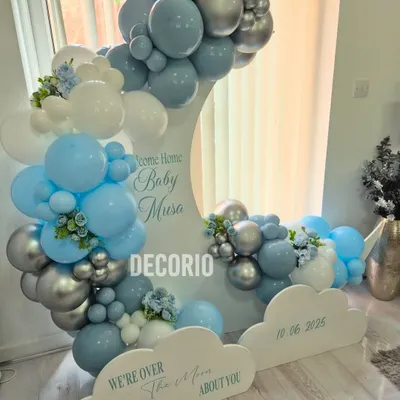A full view of the "Welcome Home Baby Musa" setup. The large crescent moon prop is the star of the show, adorned with a beautiful balloon garland and personalized with the baby's name and birthdate on the cloud cutouts.