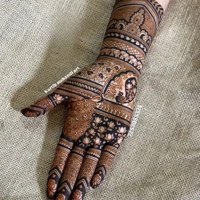 A masterpiece of traditional Indian art, this design features a majestic peacock on the palm and a royal elephant on the wrist, both symbols of grace and prosperity.
