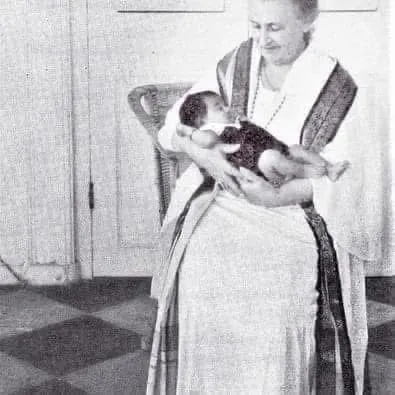 Dr. Maria Montessori, the founder of our educational method, holding a child. Her philosophy, centered on the idea to "follow the child," is the guiding principle for everything we do at Siksha.