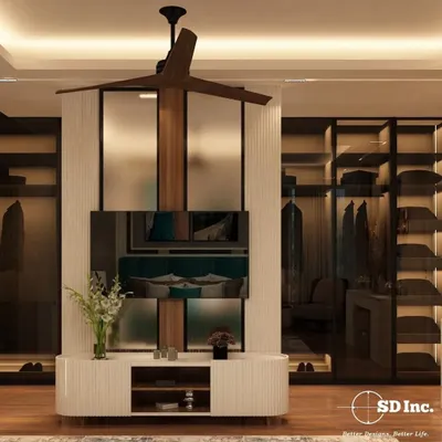 A luxurious master bedroom featuring a custom TV unit that doubles as a partition for a walk-in closet. The design uses fluted panels and a mix of wood and white finishes for a sophisticated, modern look.