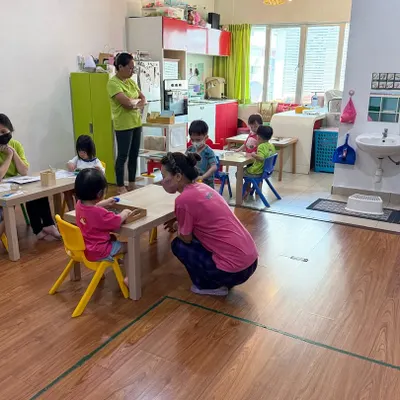 A glimpse into our four-day School Support Program in Miri, Sarawak, Malaysia. Here, a teacher kneels to connect with young children at their level in a classroom at Wonder Stars & Love Fun Kids school. This image embodies the respectful and child-centered guidance we foster.