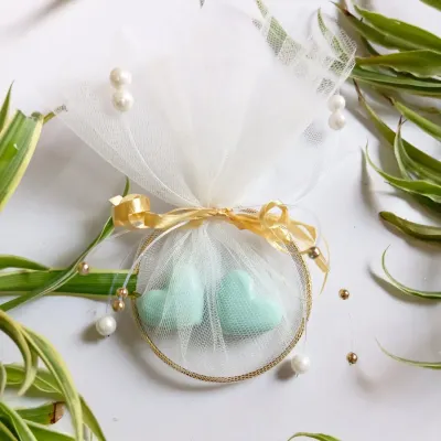 A beautifully finished wedding favor featuring two mint-green, heart-shaped soy wax melts. Packaged with a golden bangle and delicate tulle, it's a memorable gift for guests, fully customizable for your event.