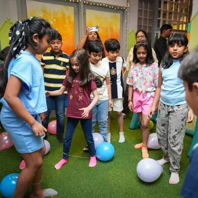 A fun and frantic balloon-popping game in progress! These organized activities are a great way for kids at a party to interact and have fun together.