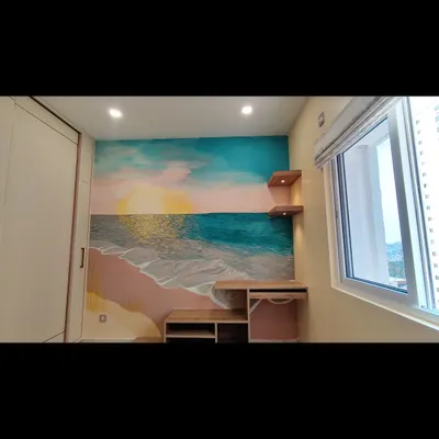 The finished seascape mural in a cozy bedroom. The design is centered around the desk and shelves, making it an integrated part of the room's decor.