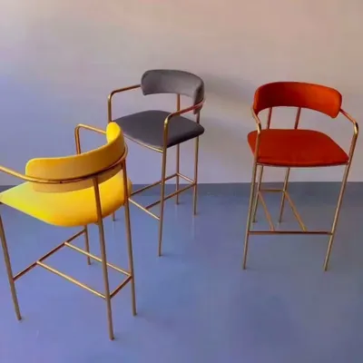 These high counter chairs feature a sleek gold-plated frame and are available in multiple colors like yellow, grey, and orange. They add a touch of modern glamour to any bar area.