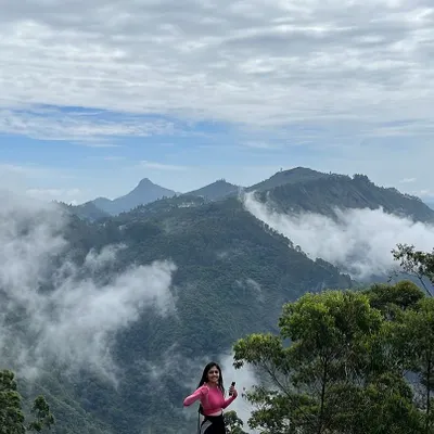 The view from the top in Kodaikanal is always worth the hike. Here's a traveler enjoying the stunning landscape of rolling hills blanketed in mist.