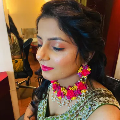 A beautiful Mehendi look. The makeup is fresh and bright, with a pop of pink on the lips that complements the floral jewelry perfectly.