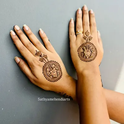 A beautiful and modern take on mehendi. This design features a circular, jewelry-like pattern on the back of the hand, connected to a matching design on the middle finger.