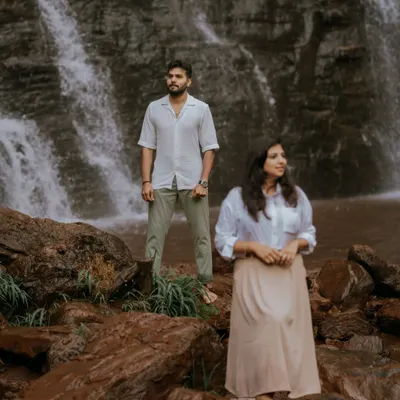 A quiet moment of reflection for the couple against a stunning waterfall backdrop. This shot emphasizes the grandeur of nature and the peaceful connection between two people.