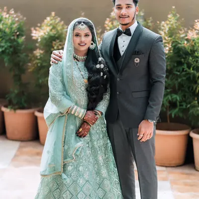 A classic portrait of a bride and groom from a Muslim wedding, showcasing their elegant reception attire.