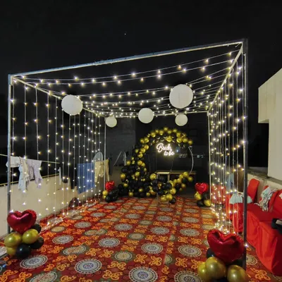 A full view of a 'Bride to be' terrace party setup. I used a canopy of fairy lights and paper lanterns to create a magical ambiance around the black and gold balloon photo booth.