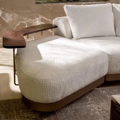 A detail of the Verona Curve Sofa, inspired by Italian mid-century modern aesthetics. The floating arm ledge, crafted from hand-finished walnut, is both a beautiful design accent and a functional surface, showcasing our approach to integrated design.