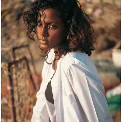 Shot during the magic of golden hour at the beach. I used the warm, setting sun as my only light source to create this soft, glowing portrait. The natural light beautifully highlights the model's curly hair and creates a dreamy, authentic mood.