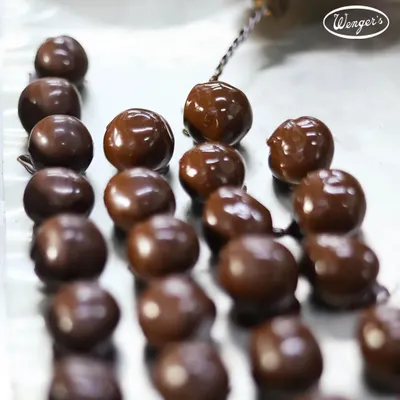 A look at our chocolate-making process. Here, our freshly made chocolate balls are being dipped one by one to create the perfect coating for our handmade truffles.
